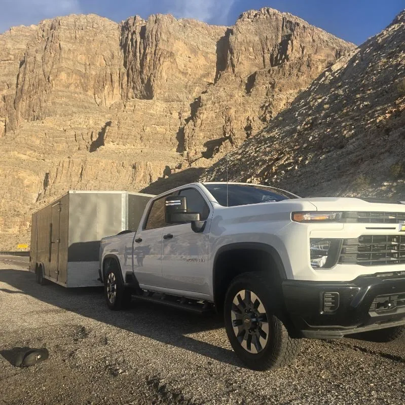 Jesse's pickup and enclosed trailer below desert canyon cliffs