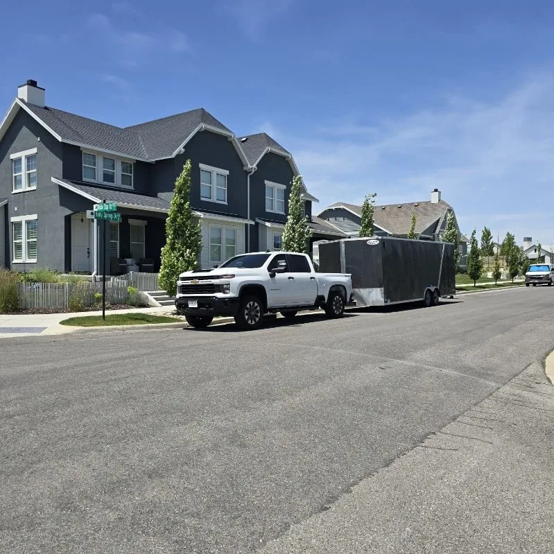 Jesse's pickup and trailer parked at a delivery in a new neighborhood